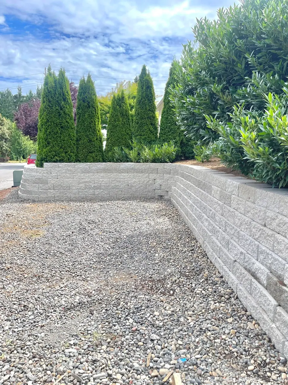 Long stepped block retaining wall built across a sloped backyard