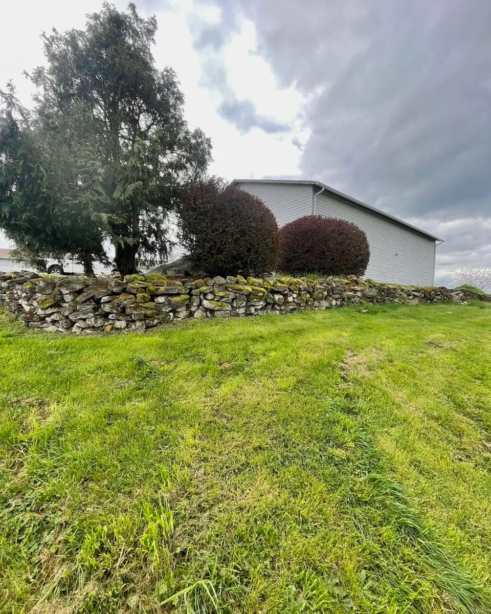 Natural rock retaining wall planted with low shrubs