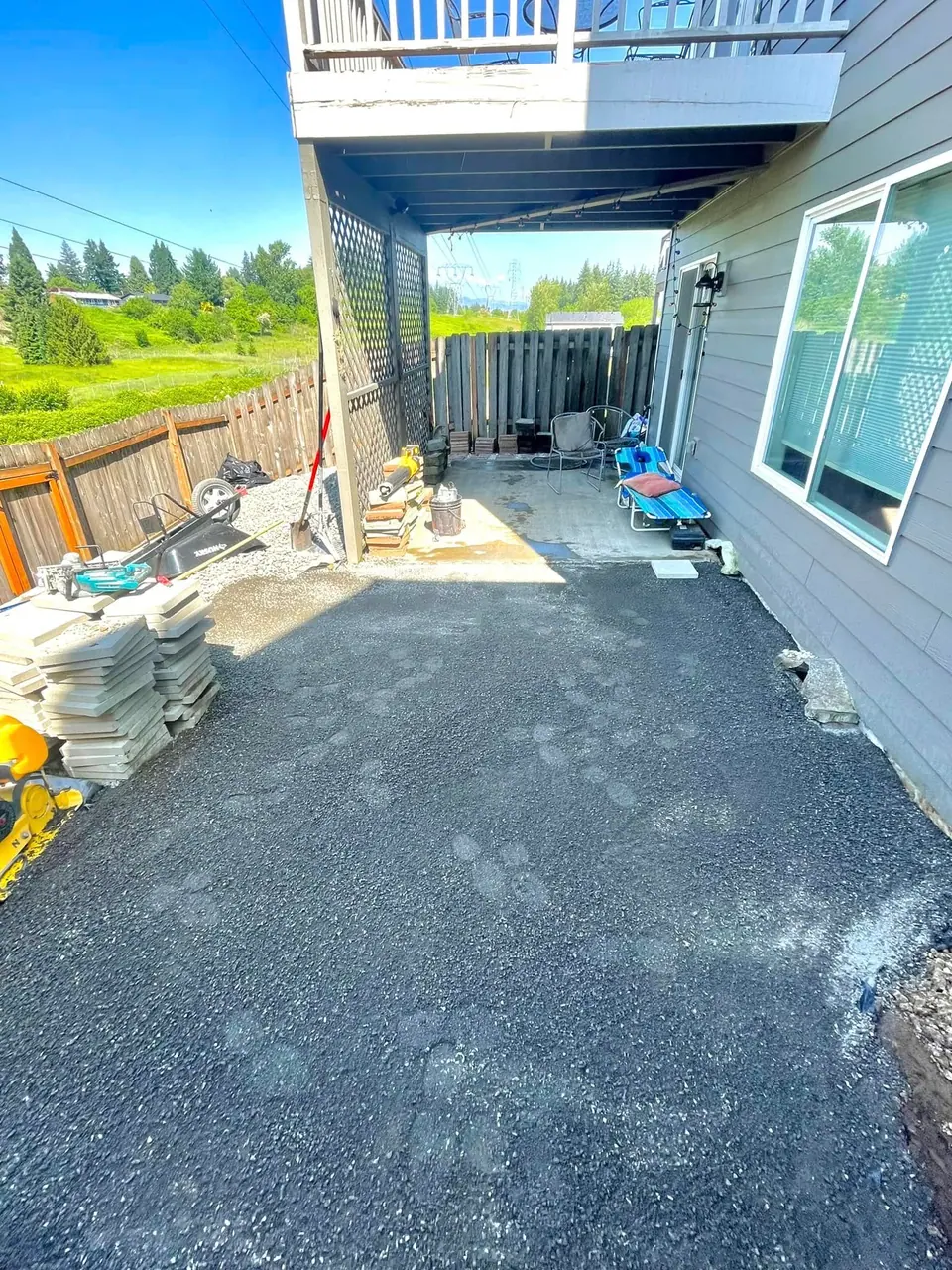 Paver patio base prepped with pallets of stone staged for installation