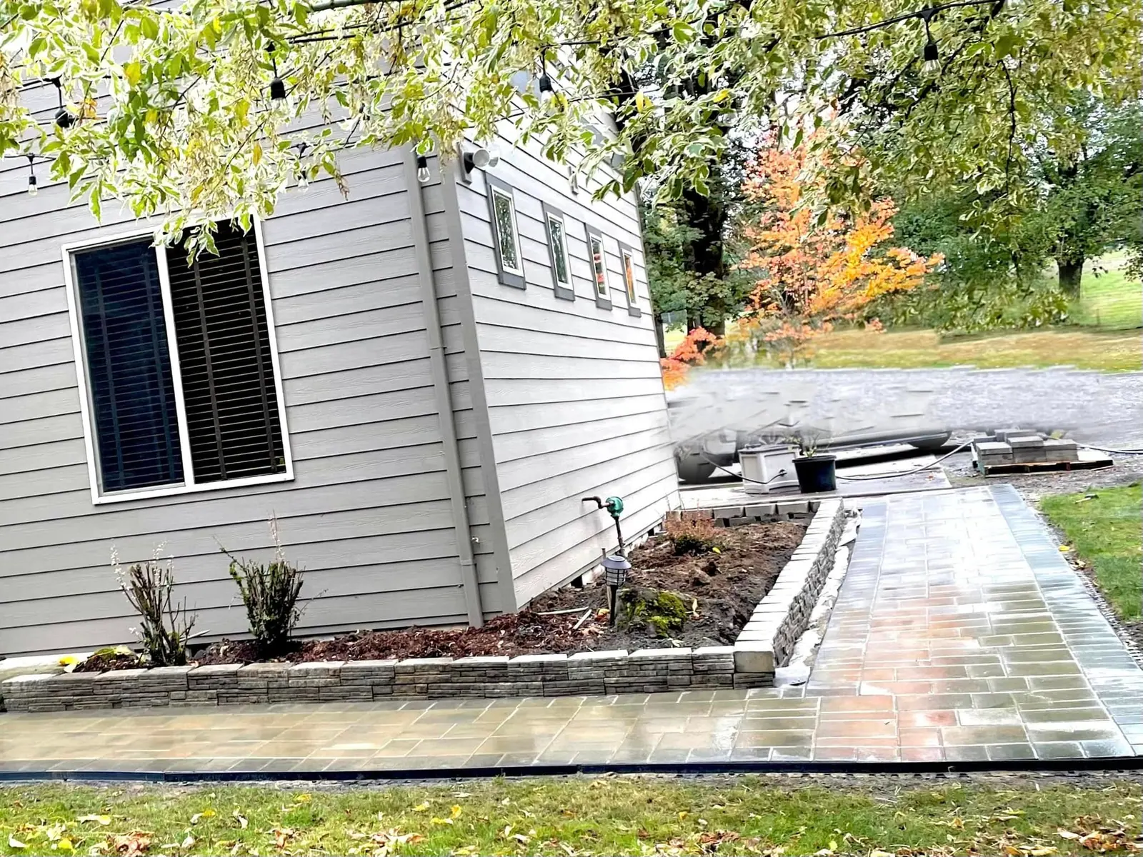 Paver walkway and planting bed running along the side of a house