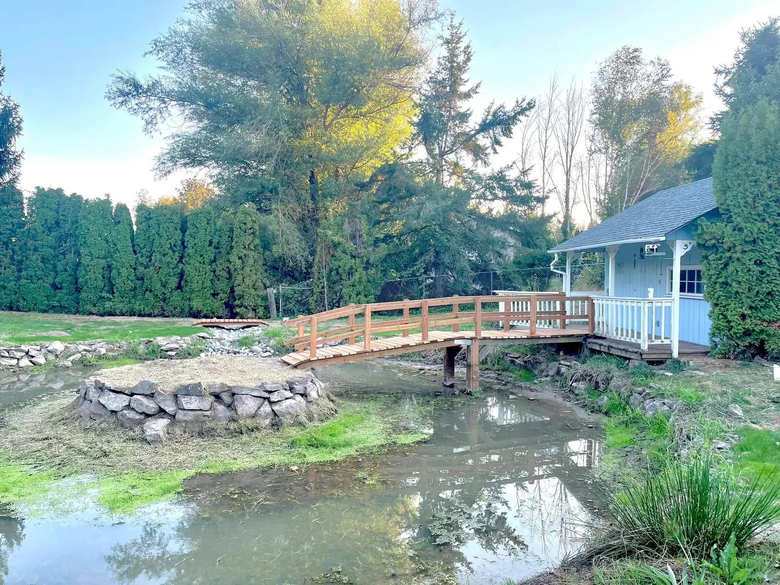 Pond and timber bridge set into a naturalized backyard landscape