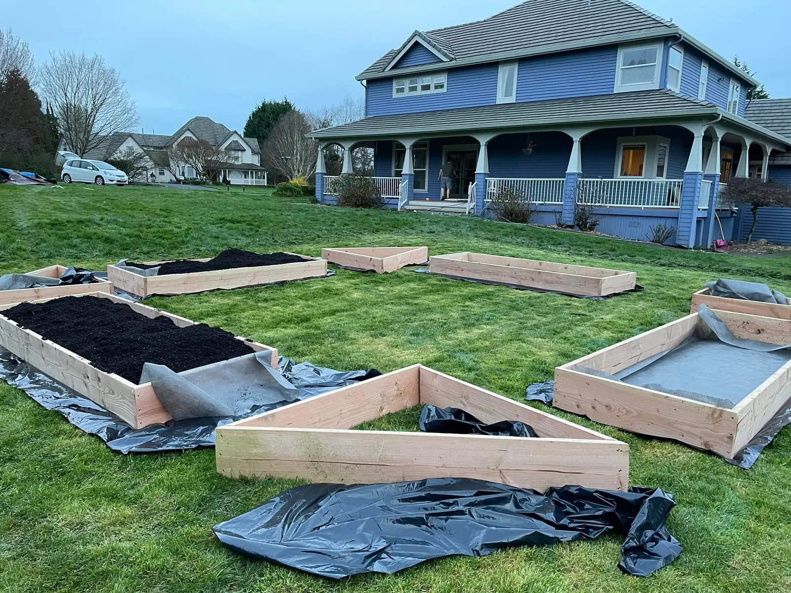 Raised garden bed frames set over landscape fabric ready for soil